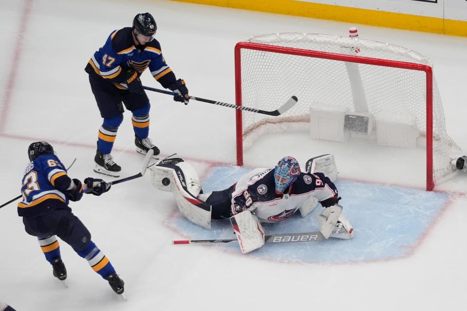 Columbus Blue Jackets goaltender Elvis Merzlikins makes a pad save on a shot by St. Louis Blues' Jake Neighbours (63) as Blues' Torey Krug (47) watches during the third period of an NHL hockey game Tuesday, Jan. 30, 2024, in St. Louis. (AP Photo/Jeff Roberson)