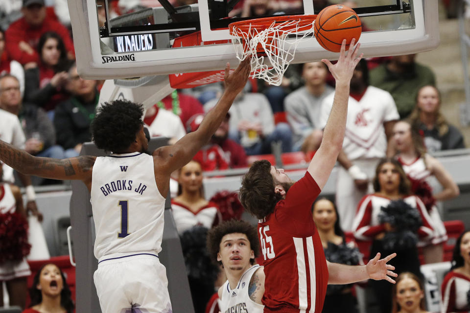 Washington State forward Oscar Cluff (45) shoots while pressured by Washington forward Keion Brooks Jr. (1) during the first half of an NCAA college basketball game, Thursday, March 7, 2024, in Pullman, Wash. (AP Photo/Young Kwak)