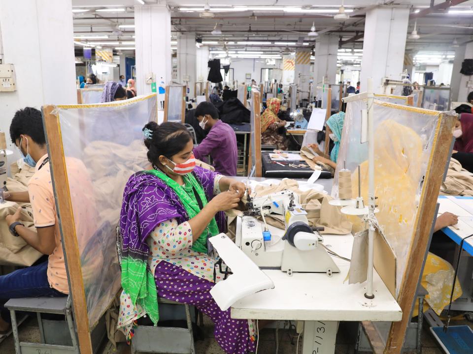 People in a textile factory in Bangladesh work on making clothing