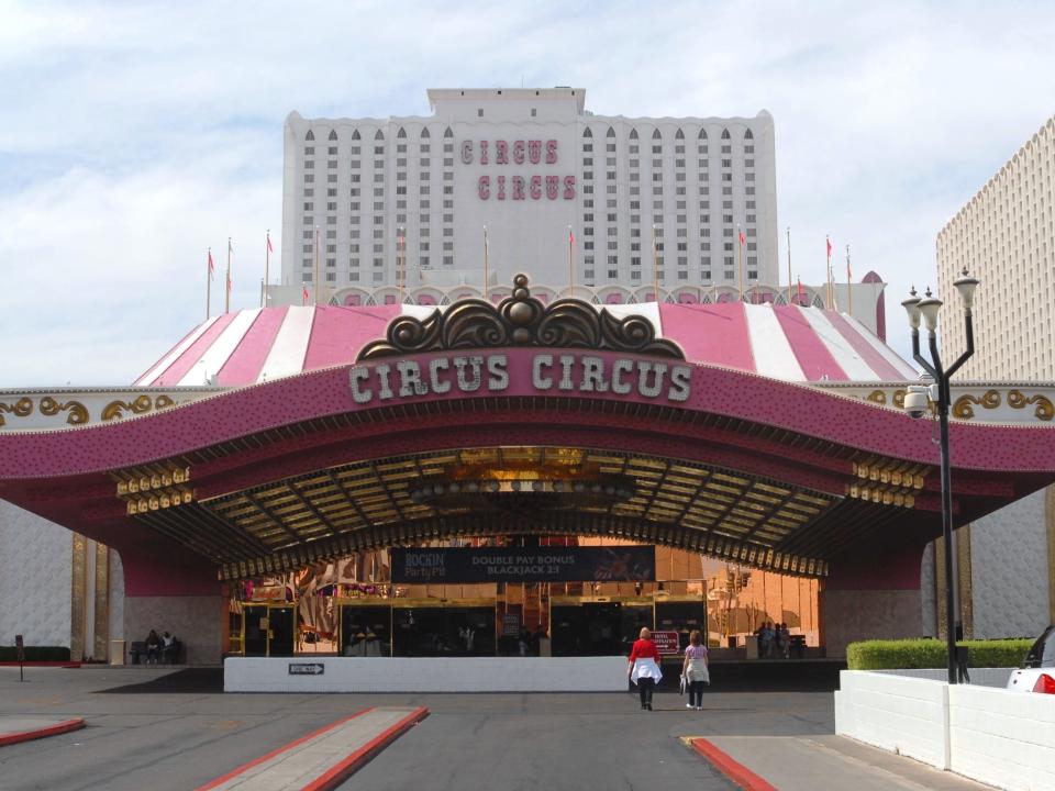 front of Circus Circus Hotel exterior (red and white) in Las Vegas with massive building behind it