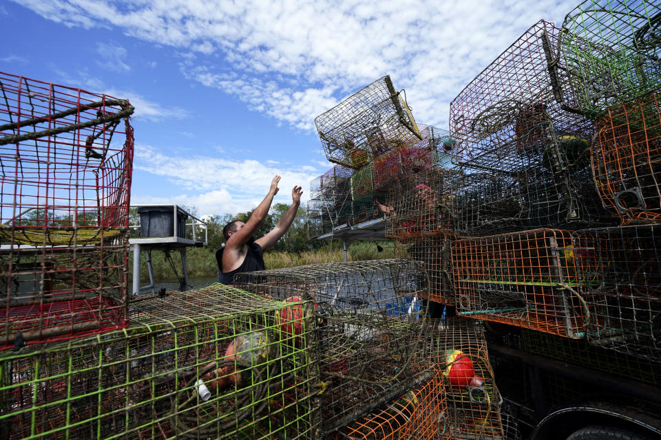 Brian Dufrene loads his crab traps on a trailer after pulling them from Bayou Dularge in anticipation of Hurricane Delta, expected to arrive along the Gulf Coast later this week, in Theriot, La., Wednesday, Oct. 7, 2020. Dufrene says he's pulled around 1,000 traps over the last three days. (AP Photo/Gerald Herbert)