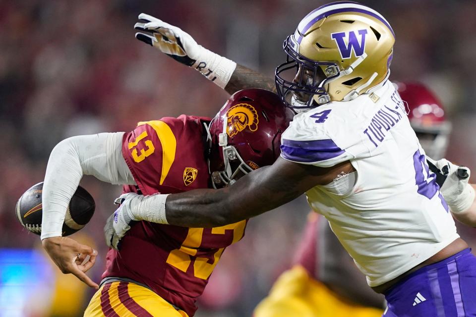 Washington defensive end Zion Tupuola-Fetui, right, forces a fumble by Southern California quarterback Caleb Williams during the first half of an NCAA college football game on Nov. 4 in Los Angeles.
