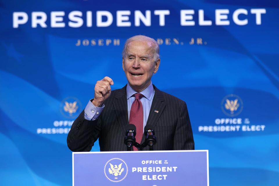 Joe Biden giving a speech under a sign that says 'President Elect.'