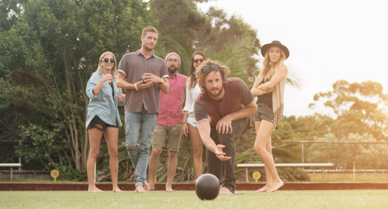 group of friends lawn bowling outside on grass against green trees, best adult friendly games, best lawn games 2022, game, games