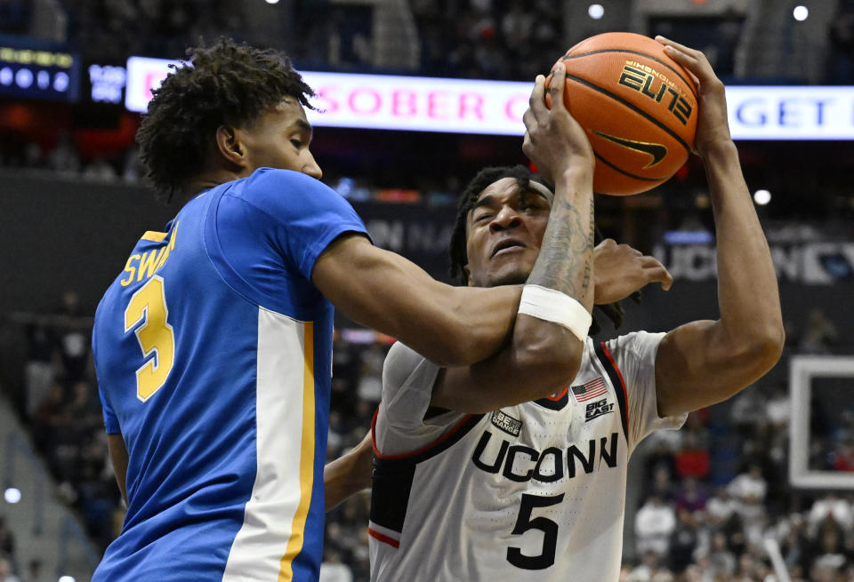UConn guard Stephon Castle (5) is guarded by Xavier guard Dailyn Swain (3) in the second half of an NCAA college basketball game, Sunday, Jan. 28, 2024, in Hartford, Conn. (AP Photo/Jessica Hill)