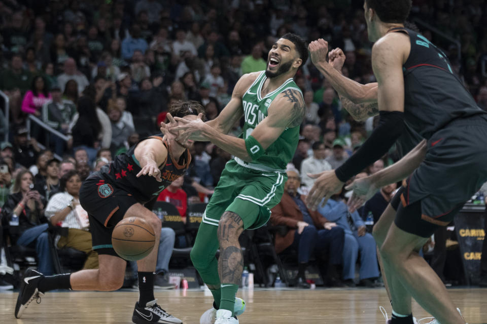 Boston Celtics forward Jayson Tatum, center, loses the ball after it was knocked away by Washington Wizards forward Corey Kispert, left, during the second half of an NBA basketball game in Washington, Sunday, March 17, 2024. (AP Photo/Manuel Balce Ceneta)