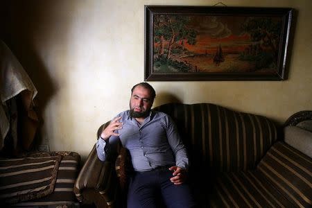 Amer Zaydan, one of the survivors of a chemical attack in the Ghouta region of Damascus that took place in 2013, speaks while sitting at his house in the Ghouta town of Ain Tarma, Syria April 7, 2017. Picture taken April 7, 2017. REUTERS/Bassam Khabieh