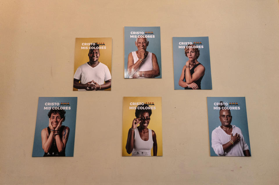 Posters featuring church members with a message that reads in Spanish: "Christ loves my colors", are displayed on a wall at the Metropolitan Community Church, an LGBTQ+ inclusive house of worship, in Matanzas, Cuba, Friday, Feb. 2, 2024. Members of Cuba’s LGBTQ+ community say a 2022 government-backed “family law” that allows same-sex couples the right to marry and adopt marked a milestone. (AP Photo/Ramon Espinosa)