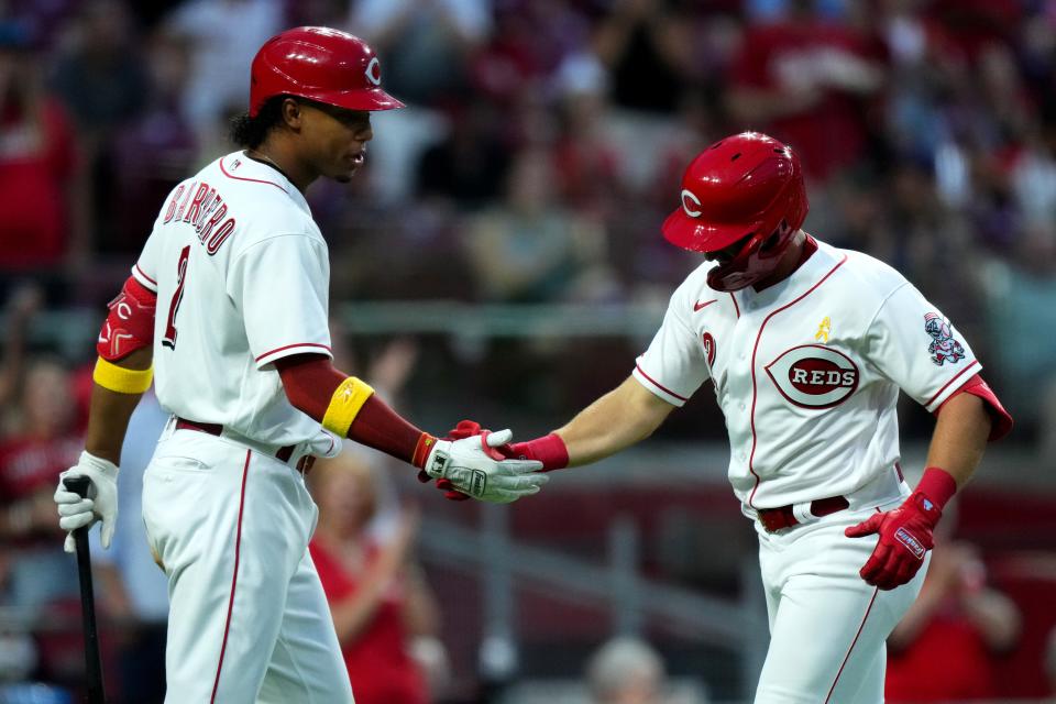 Cincinnati Reds third baseman Spencer Steer (12) is congratulated by Cincinnati Reds shortstop Jose Barrero (2) after hitting a solo home run during the fifth inning of a baseball game against the Colorado Rockies, Friday, Sept. 2, 2022, at Great American Ball Park in Cincinnati. The hit marked the first of Steer’s major-league career. 