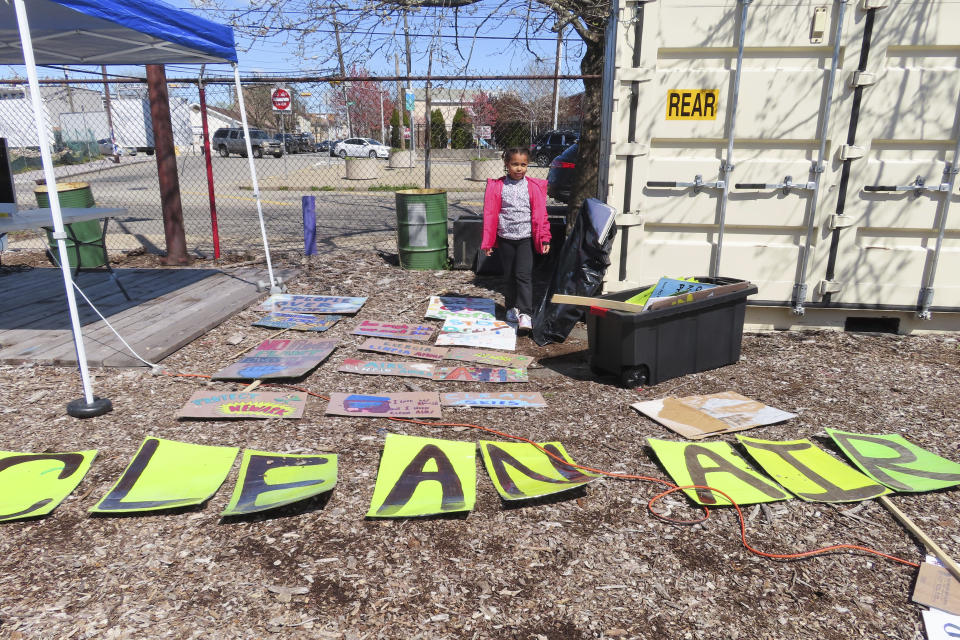 Eight-year-old Sapphire Tate arranges signs before a protest against a proposed backup power plant for a sewage treatment facility in Newark, N.J., on April 20, 2022. On Jan. 26, 2024, NJ Transit scrapped plans for a similar gas-fired backup power plant in nearby Kearny, renewing calls for the Newark project to be abandoned as well in a community that is already overburdened by pollution. (AP Photo/Wayne Parry)