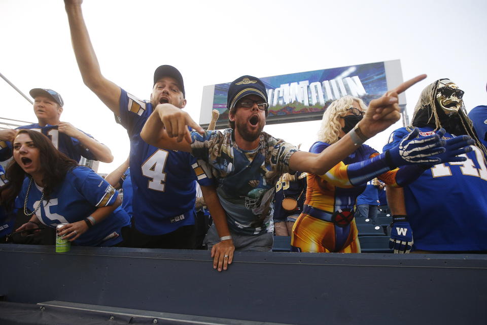 Winnipeg Blue Bombers fans celebrate after wide receiver Kenny Lawler scored a touchdown against the Hamilton Tiger-Cats during the first half of a Canadian Football League game Thursday, Aug. 5, 2021, in Winnipeg, Manitoba. (John Woods/The Canadian Press via AP)