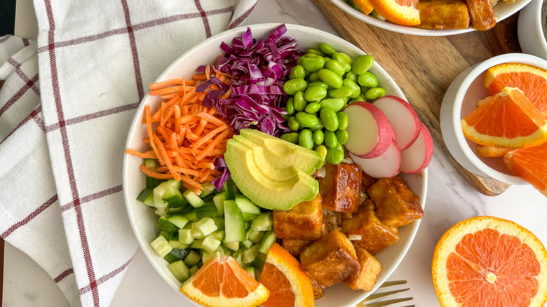 orange tofu rice bowl with colorful vegetables