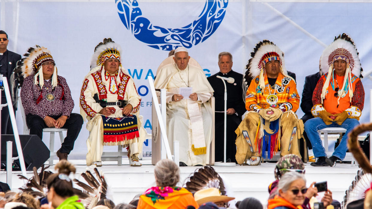 Pope Francis sits between grand chiefs during his visit to Maskwacis, Canada.