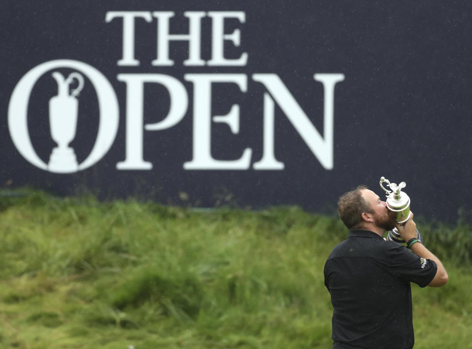 FILE - In this Sunday, July 21, 2019 file photo Ireland's Shane Lowry holds and kisses the Claret Jug trophy on the 18th green as he poses for the crowd and media after winning the British Open Golf Championships at Royal Portrush in Northern Ireland. The organizers of the British Open announced Monday April 6, 2020, that they have decided to cancel the event in 2020 due to the current Covid-19 pandemic and that the Championship will next be played at Royal St George's in 2021. (AP Photo/Peter Morrison)