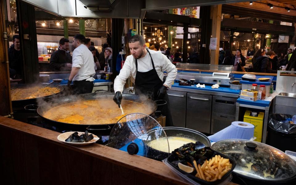 Large pans of street food paella and the makers at Borough Market