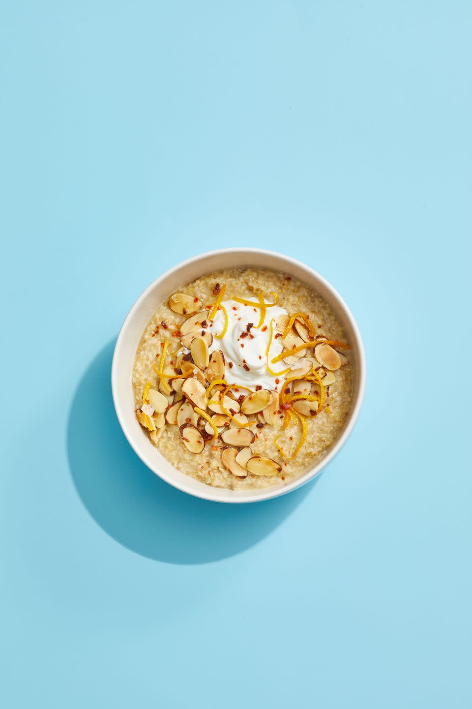 oatmeal with yogurt and toasted almonds on a blue background