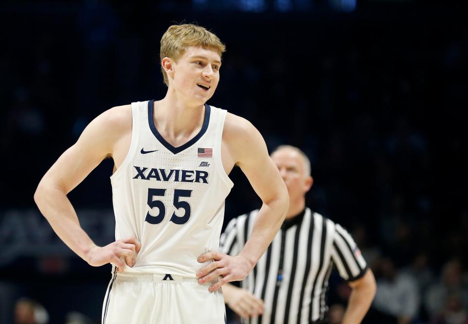 Xavier Musketeers guard J.P. Macura (55) comments toward Providence Friars head coach Ed Cooley after a play in the first half of the NCAA Big East game between the Xavier Musketeers and the Providence Friars at the Cintas Center in Cincinnati on Wednesday, Feb. 28, 2018. At halftime Xavier led 40-37.