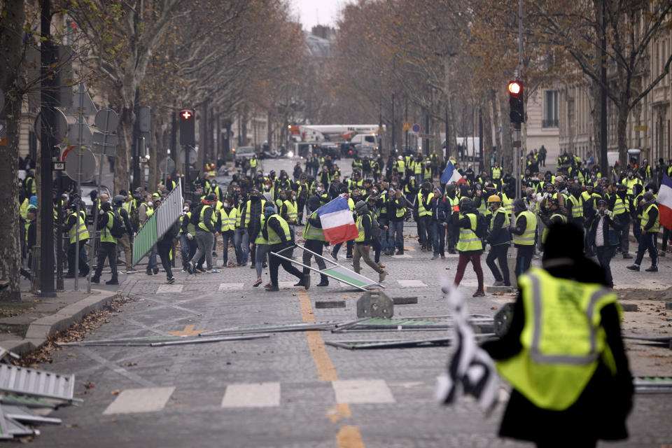 Demonstrators build a barricade near the Champs-Elysees avenue during a demonstration Saturday, Dec. 1, 2018 in Paris. French authorities have deployed thousands of police on Paris' Champs-Elysees avenue to try to contain protests by people angry over rising taxes and Emmanuel Macron's presidency. (AP Photo/Kamil Zihnioglu)