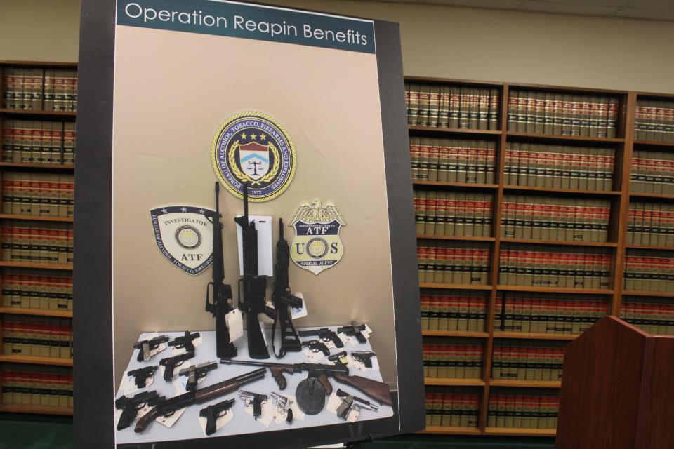 Federal prosecutors said 23 guns were seized during an investigation into an alleged drug ring with connections to the Grim Reapers Motorcycle Club.