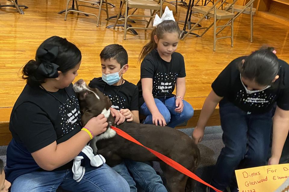 “Sonny” and “Cher” – dogs from the Amarillo Animal Management and Welfare Department – greet students from Glenwood Elementary in recognition of the school’s “Dimes for Dogs” fundraiser.
