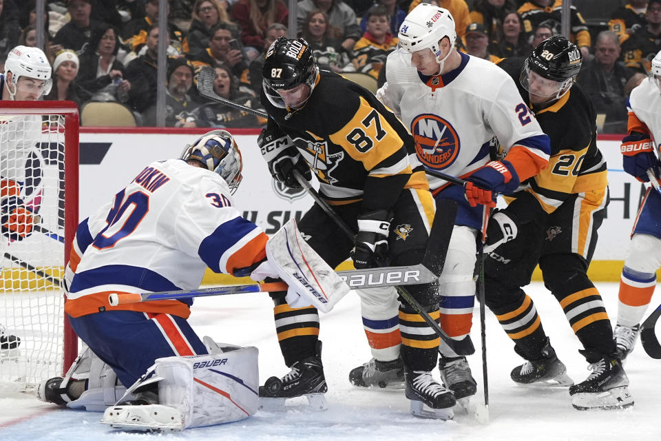 Pittsburgh Penguins' Sidney Crosby (87) can't get his stick on a rebound off New York Islanders goaltender Ilya Sorokin (30) with Scott Mayfield (24) defending during the second period of an NHL hockey game in Pittsburgh, Tuesday, Feb. 20, 2024. (AP Photo/Gene Puskar)