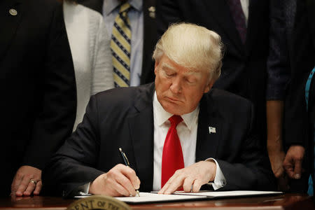 U.S. President Donald Trump signs an executive order on education as he participates in a federalism event with Governors at the White House in Washington, DC, U.S. April 26, 2017. REUTERS/Carlos Barria