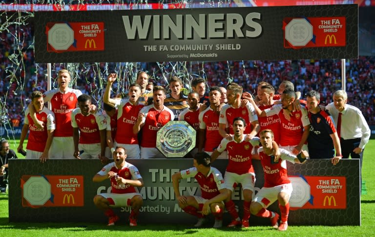 Arsenal's French manager Arsene Wenger (R) and his players celebrate with the trophy after beating Chelsea in the FA Community Shield football match between Arsenal and Chelsea at Wembley Stadium in north London on August 2, 2015