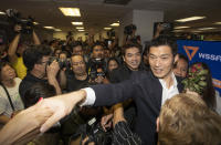 Thailand's Future Forward Party leader Thanathorn Juangroongruangkit shakes hands with supporters at the party's headquarters in Bangkok, Thailand, Tuesday, Jan. 21, 2020. Thailand's Constitutional Court acquitted the country's third-biggest political party of seeking the overthrow of the country's constitutional monarchy. The court ruled Tuesday that the Future Forward Party showed no intention of committing the offense, and that the complaint had not been filed according to the correct legal procedure. (AP Photo/Sakchai Lalit)