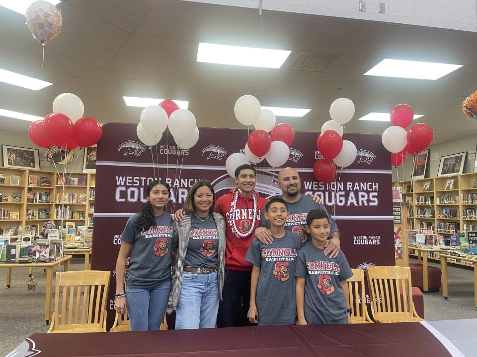 Weston Ranch's Mateen Rafiq (center) poses for a photo alongside his family sporting Cornell University gear for National Signing Day at Weston Ranch High School on Nov. 8, 2023.