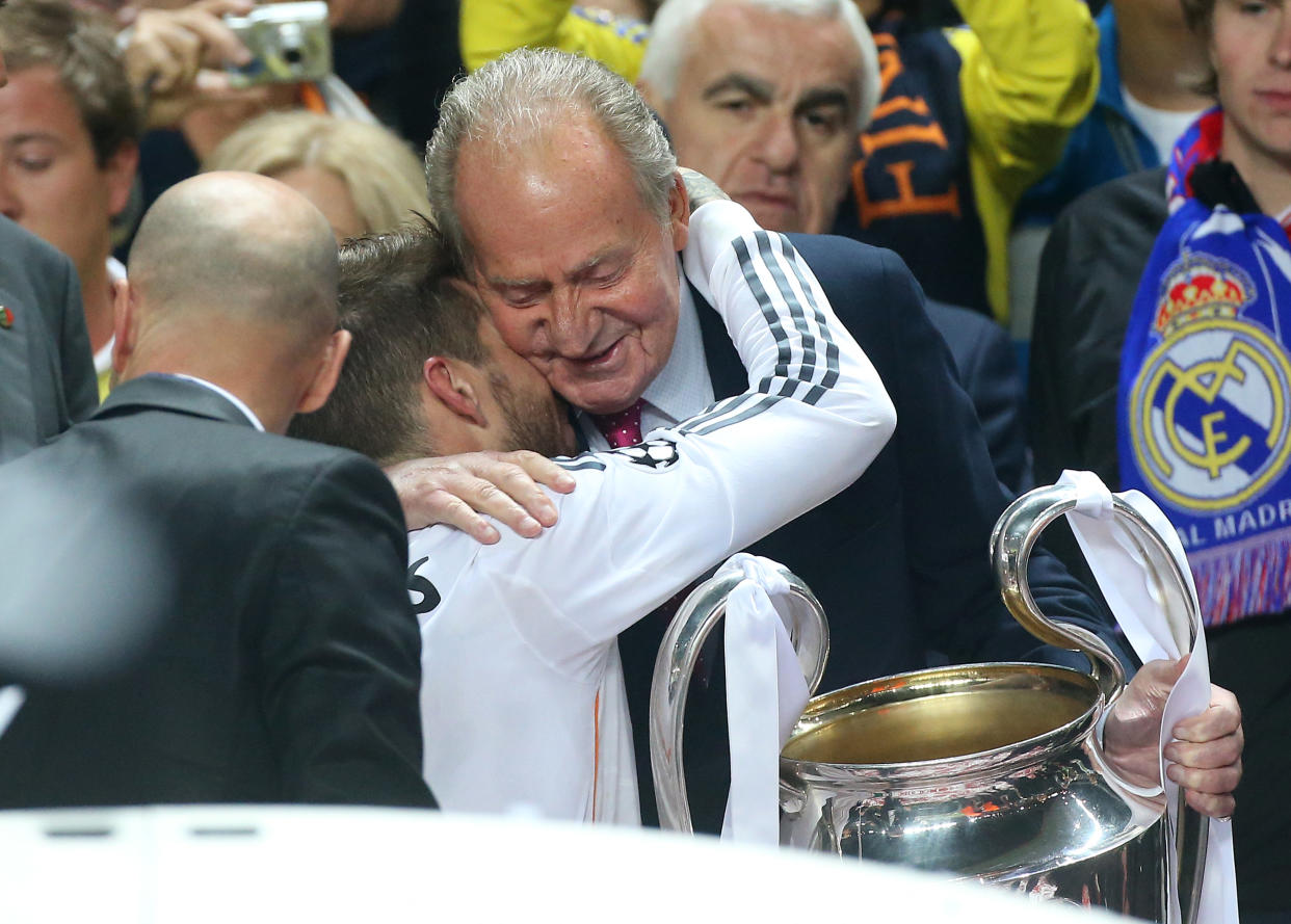 Juan Carlos I abraza a Sergio Ramos junto al trofeo de la Champions League de 2014.