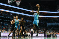 Charlotte Hornets forward Miles Bridges (0) shoots over Cleveland Cavaliers forward Evan Mobley (4) as Charlotte Hornets forward Grant Williams (2) looks on during the first half of an NBA basketball game in Charlotte, N.C., Wednesday, March 27, 2024. (AP Photo/Nell Redmond)