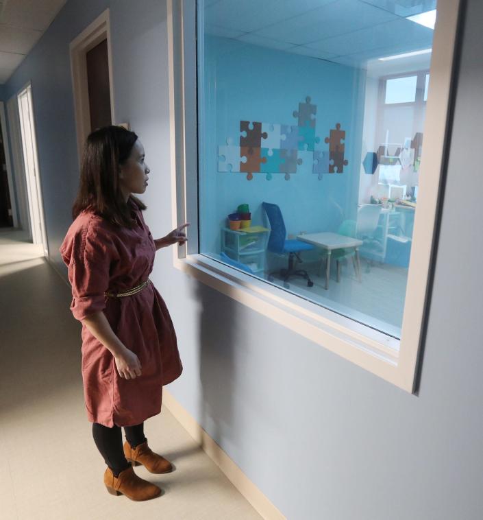 CEO Kim Wolff looks through one-way glass into a classroom at Wolff &amp; Phan Autism Center, a clinic for children with autism.