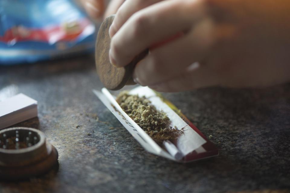 In this photo taken Friday, Dec. 20, 2013, a visitor rolls a marijuana joint in coffee shop Mississippi in Maastricht, southern Netherlands. While several U.S. states have moved to legalize the sale of marijuana, the Netherlands is going in the opposite direction, clamping down on its famed tolerance policy toward weed. In Maastricht, attempts to ban foreigners from buying weed have led to a resurgence of street-dealers, while Amsterdam is shutting marijuana cafes located too close to schools. (AP Photo/Ermindo Armino)
