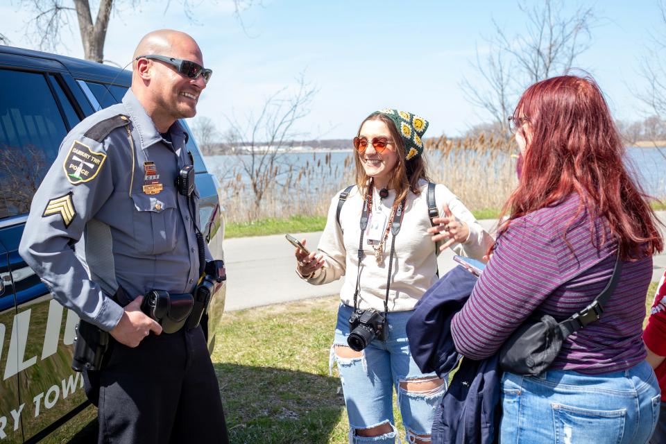 MCCC Agora reporter Destiny Gallina, center, and Agora editor Maggie Sandefur, right, interview Brad LaMarca, patrol sergeant with the Danbury Township Police Department. The reporters were learning about the security that was in place for the event Monday at East Harbor State Park in Ohio.