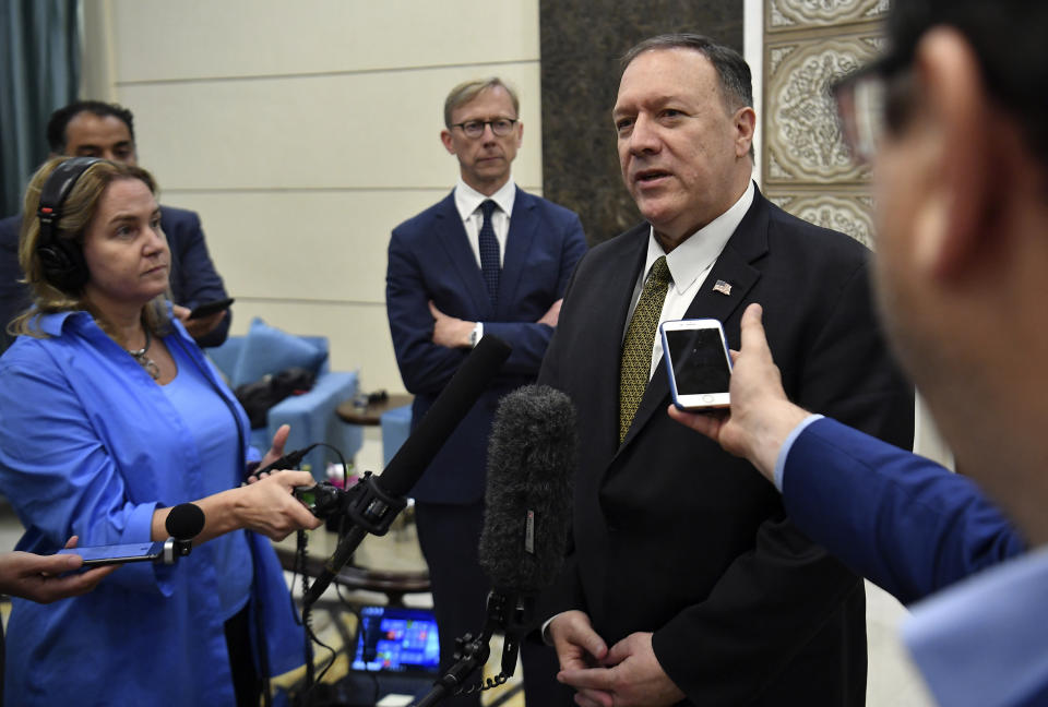 U.S. Secretary of State Mike Pompeo speaks to the media before departing from al-Bateen Air Base in Abu Dhabi, United Arab Emirates, Thursday, Sept. 19, 2019, as U.S. special representative on Iran Brian Hook, left, listens. (Mandel Ngan/Pool via AP)