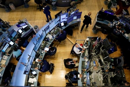 FILE PHOTO: Traders work on the floor at the NYSE in New York