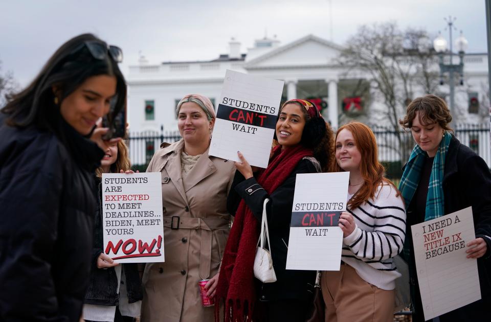 A group of Title IX reform advocates holds up signs saying "students can't wait" during a protest outside the White House on Tuesday.