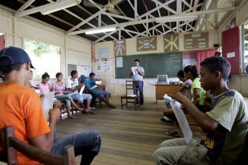 Brazilian teacher AdÃ£o da Costa (C) gives a "tele-learning" class at a public school in Xapuri, in northern Brazil. Teachers, who are scarce in some regions of Brazil, are now conducting lessons streamed to students in the village of Tumbira using an Internet connection made possible with a generator-powered radio signal
