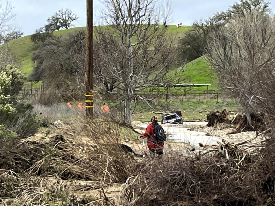 In this photo provided by Neil Collins, the SUV belonging to Lindsy Doan sits in floodwaters on Monday, Jan. 9, 2023, in San Miguel, Calif. Doan, along with her son, Kyle Doan, were swept away by rising floodwaters near the San Marcos Creek in San Miguel. The mother was eventually rescued, but her 5-year-old son remains missing. (Neil Collins via AP)