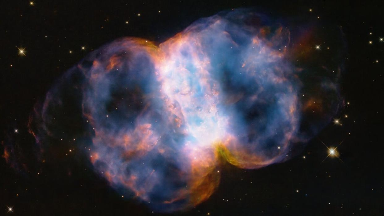  The Little Dumbbell Nebula, a colorful, barbell-shaped cloud of gas, as seen by the Hubble Space Telescope. 