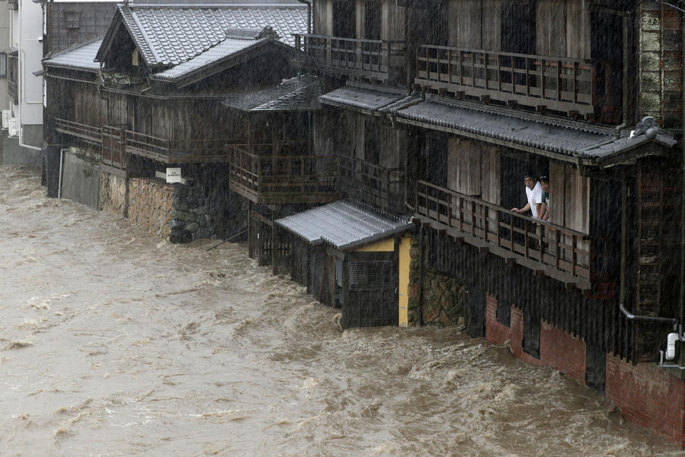 People watch the Isuzu River swollen by Typhoon Hagibis, in Ise, central Japan Oct. 12, 2019. (Photo: Kyodo News via AP)