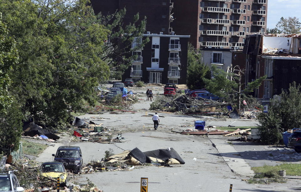 Personas caminan a un lado de los escombros en Gatineau, Quebec, el sábado 22 de septiembre de 2018. (Fred Chartrand/The Canadian Press vía AP)