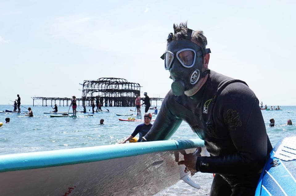 Protesters emerged from the sea at Brighton West Pier as Surfers Against Sewage held a UK-wide paddle-out protest against pollution earlier this year (PA)