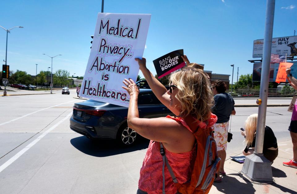 A woman holds a sign during the Rally for Reproductive Freedom at 14th and Erie Avenue, Sunday, June 26, 2022, in Sheboygan, Wis.  The rally, sponsored by the Sheboygan Abortion Rights Coalition, is a response to the United States Supreme Court decision which reversed Roe v. Wade this past Friday.