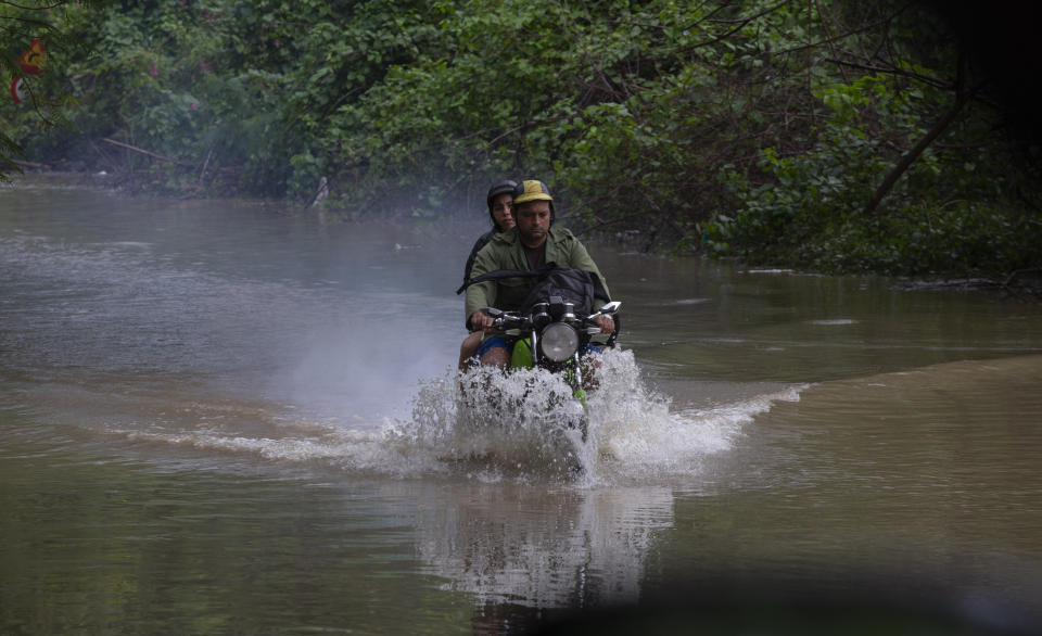 Una motocicleta avanza por una vía inundada por lluvias torrenciales, en La Habana, Cuba, el miércoles 13 diciembre de 2023. (AP Foto/Ismael Francisco)