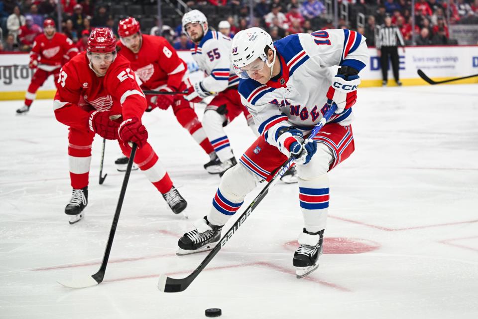 Rangers left wing Artemi Panarin brings the puck up ice against Red Wings defenseman Moritz Seider during the first period on Friday, April 5, 2024, at Little Caesars Arena.