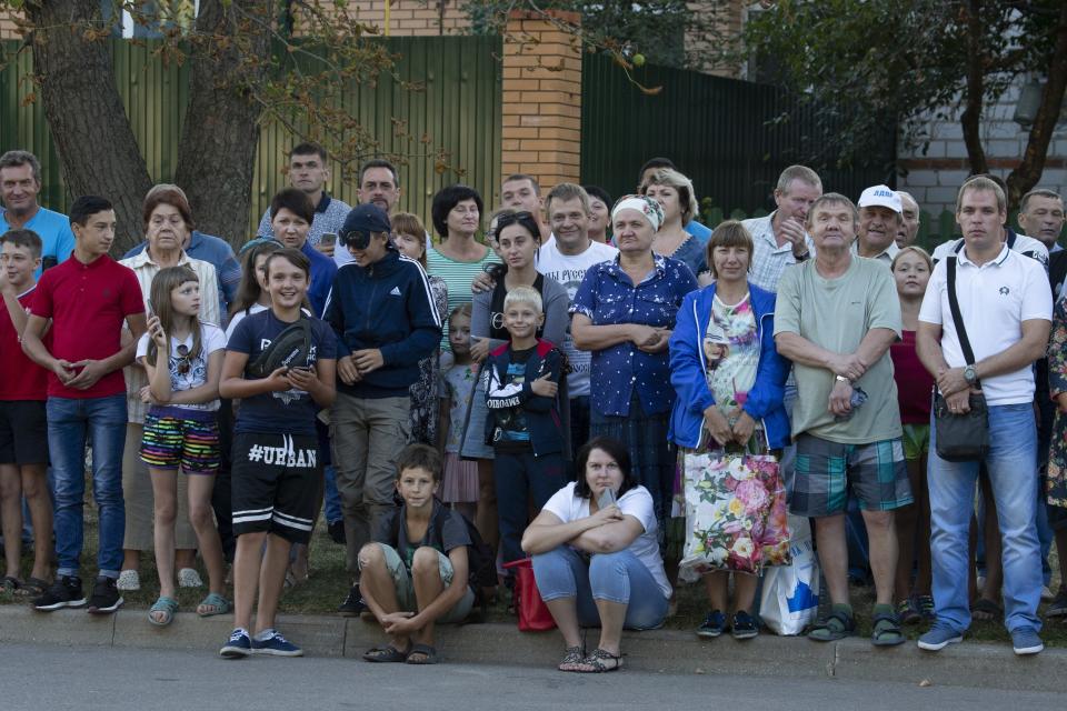 Local people gather to see Russian President Vladimir Putin's arrival to attend a meeting with WWII veterans activists the Kursk Battle memorial museum in Kursk, 426 kilometers (266 miles) south of Moscow, Russia, Thursday, Aug. 23, 2018. Putin attends a ceremony marking the 75th anniversary of the battle of Kursk in which the Soviet army routed Nazi troops. It is described by historians as the largest tank battle in history involving thousands of tanks. (AP Photo/Alexander Zemlianichenko, Pool)