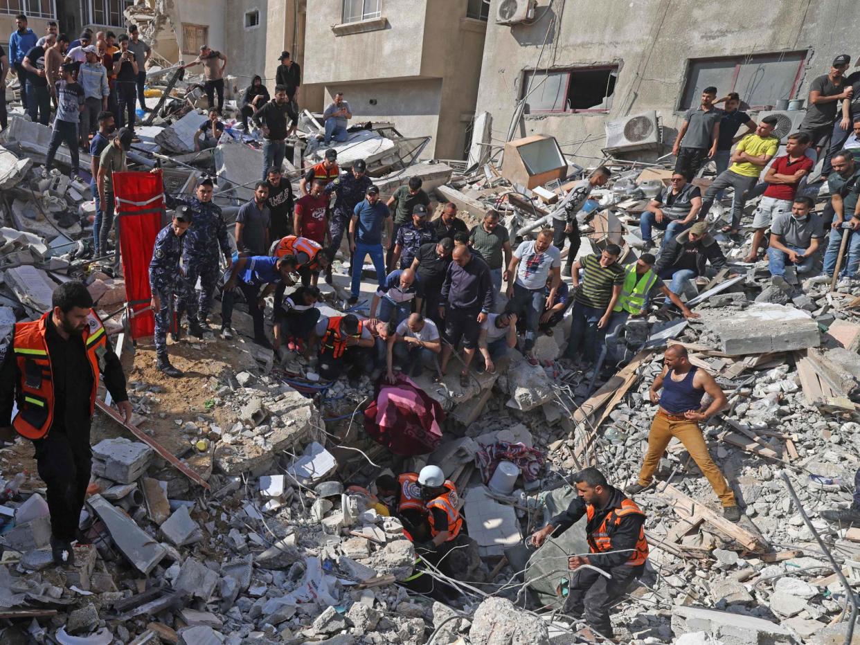 <p>Palestinian paramedics search for survivors under the rubble of a destroyed building in Gaza City on Sunday</p> (AFP/Getty)