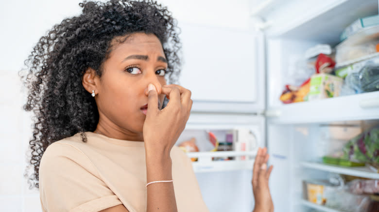 woman disgusted by something in fridge