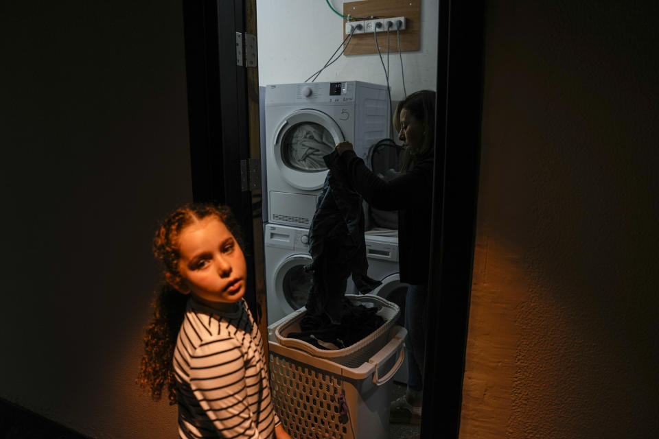 Michal Nidam Elharar and her daughter Omer, evacuated from Kiryat Shmona, sort laundry at the hotel in Tiberias, northern Israel, Tuesday, March 5, 2024. Around 60,000 Israelis who evacuated from cities and towns along the border with Lebanon are grappling with the question of when they will be able to return home. Hezbollah began launching rockets towards Israel one day after Hamas-led militants stormed into southern Israel on Oct. 7. (AP Photo/Ariel Schalit)